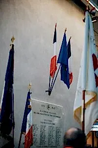 a group of flags hanging from the side of a wall