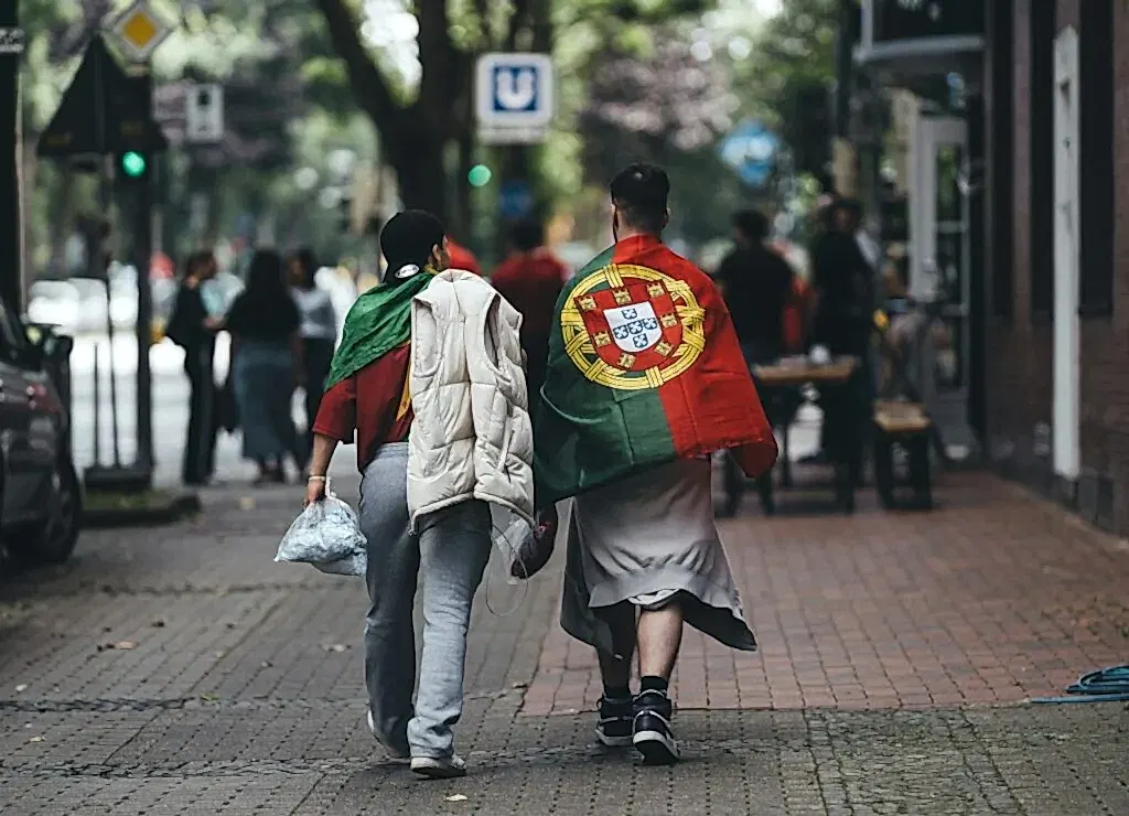A couple of people walking down a street