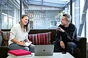 woman in white long sleeve shirt sitting on red couch